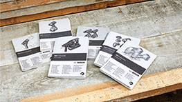 Six Bosch Professional manuals are lying on a wooden surface.