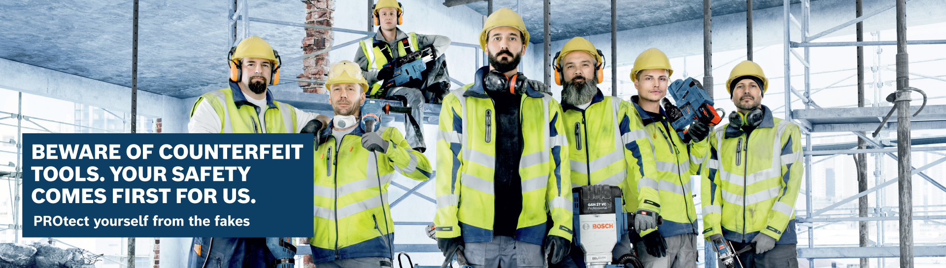 Six men in yellow safety helmets and jackets with tools.