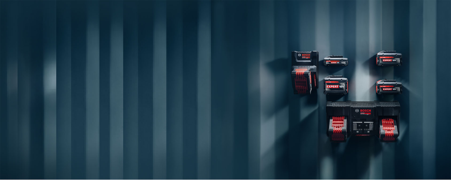Various Bosch Professional batteries mounted on a blue wall.