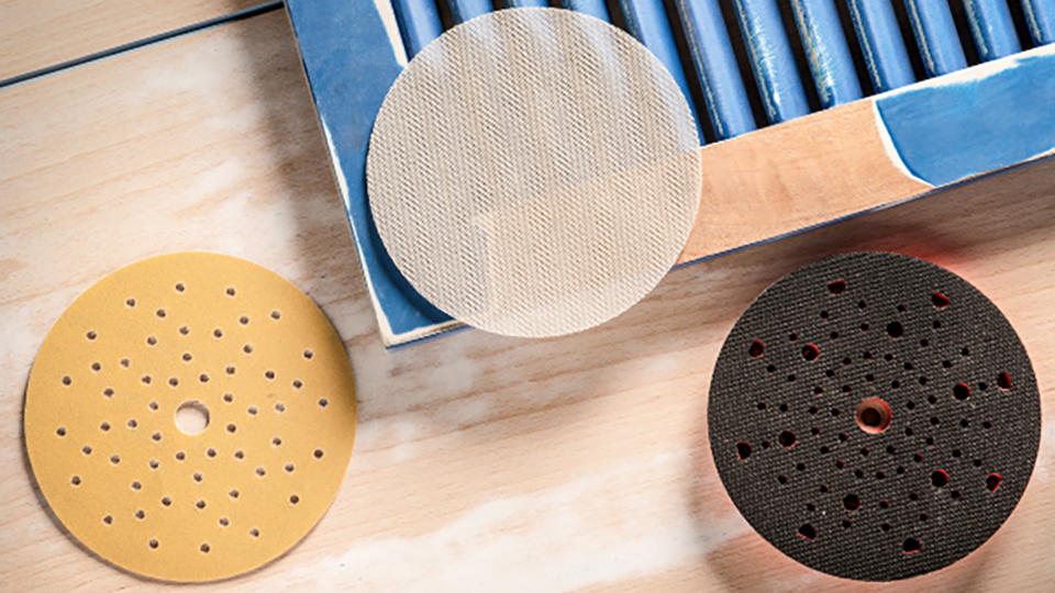 Three grinding discs on a wooden table: yellow, black, beige.