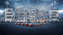 Bosch Professional tools on shelves and the floor in a workshop.