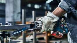 A Bosch Professional cordless angle grinder is held by one hand.